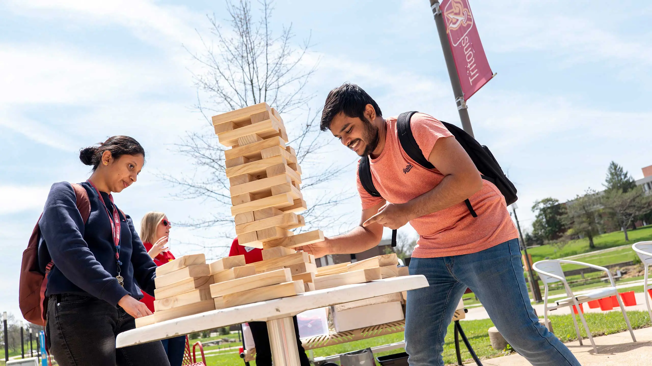 Students playing wooden block game outside